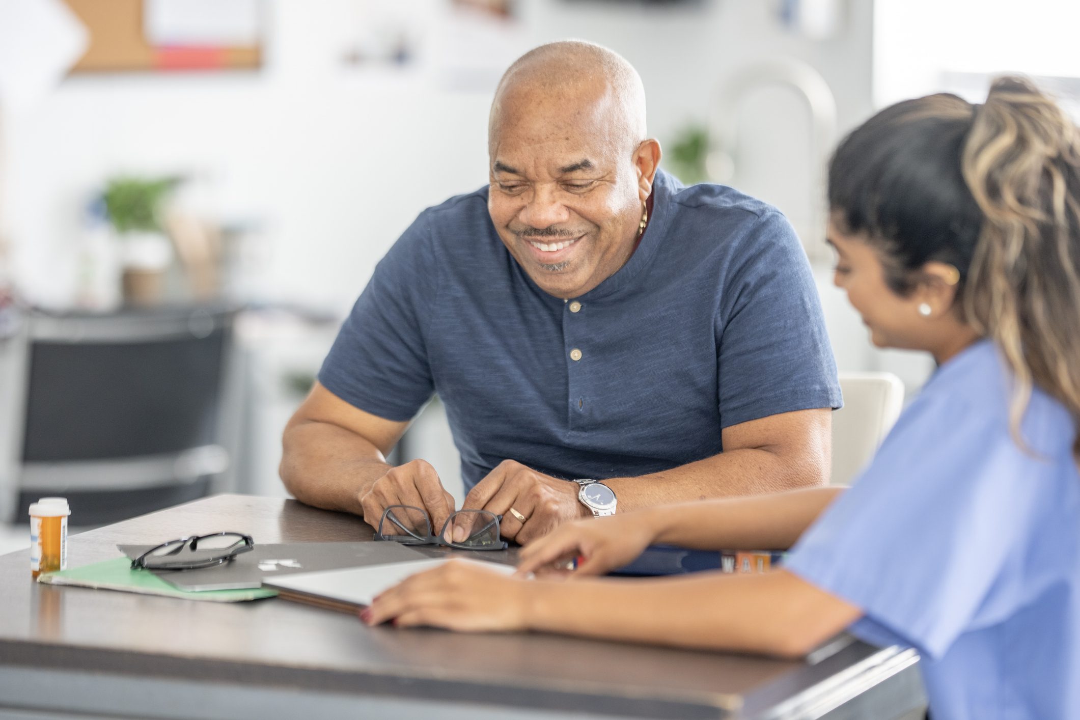 Man and nurse reviewing information at table.